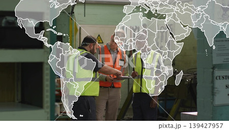 Reviewing clipboard three men in hi-vis vests discussing on factory floor, with world map overlay Reviewing clipboard three men in hi-vis vests discussing on factory floor, with world map overlay 139427957