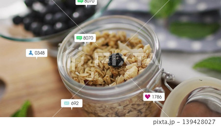 Displaying granola jar sitting on wooden board at kitchen table, with hinged lid and social icons Displaying granola jar sitting on wooden board at kitchen table, with hinged lid and social icons 139428027