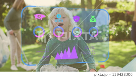 Laughing child wearing green top and tulle playing in sunlit backyard with AR HUD and bubbles 139428300