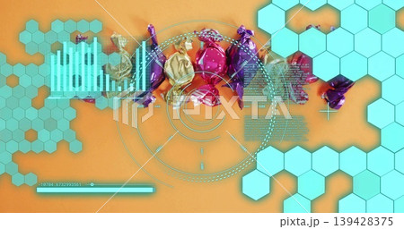Displaying foil-wrapped candies shimmering in studio flat-lay on orange surface, with turquoise HUD 139428375