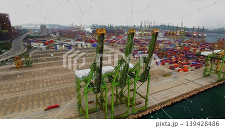Dominating three tall green gantry cranes lining quay, showing colorful container stacks, red truck 139428486