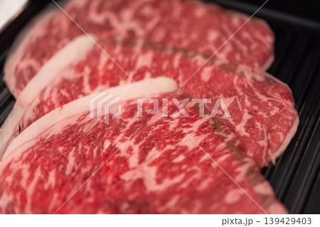 Close up of raw marbled beef slices with rich fat texture fresh meat preparation ingredient for cooking steak or grill high quality protein food Close up of raw marbled beef slices with rich fat texture fresh meat preparation ingredient for cooking steak or grill high quality protein food 139429403