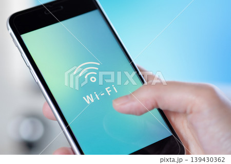 手に持ったスマホに表示されたフリーWi-Fiのアイコン。オリジナルイメージ画像 139430362