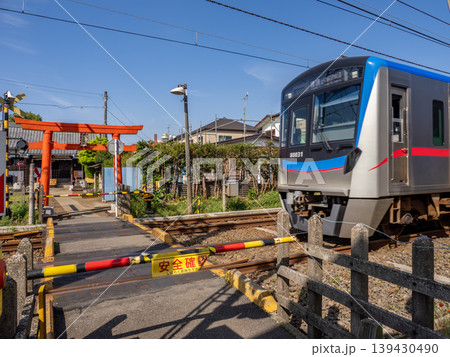 電車が通過する参道の踏切　異色の鉄道風景と鳥居　右京塚神社 139430490