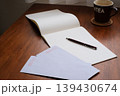 机の上の便箋と封筒とペンとマグカップ 139430674