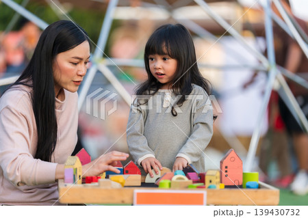 mother and preschool child girl playing with wooden toy block at outdoor mother and preschool child girl playing with wooden toy block at outdoor 139430732