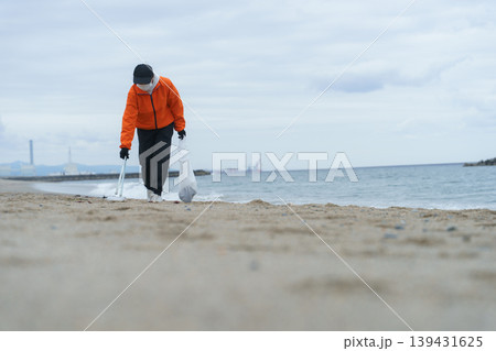 砂浜でゴミ拾いをする人 砂浜でゴミ拾いをする人 139431625