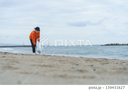 砂浜でゴミ拾いをする人 砂浜でゴミ拾いをする人 139431627