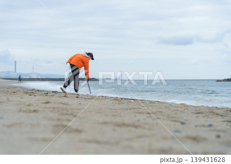 砂浜でゴミ拾いをする人 砂浜でゴミ拾いをする人 139431628
