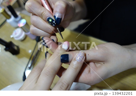 Nail Artist Applying Glitter Detail to Client's Nail Nail Artist Applying Glitter Detail to Client's Nail 139432201