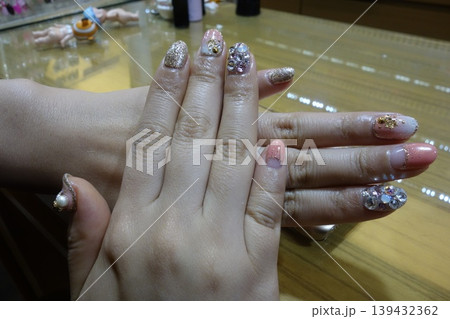 Elegant Nail Art with Glitter and Gemstone Details 139432362