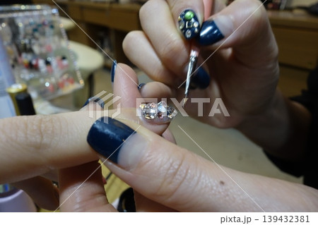 Nail Artistry: Rhinestone Application on Dark Blue Nails Nail Artistry: Rhinestone Application on Dark Blue Nails 139432381