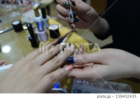 Nail Technician Applying Polish to Client's Nails Nail Technician Applying Polish to Client's Nails 139432435
