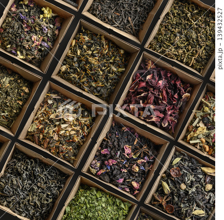 Assorted vivid herbal teas arranged in attractive square containers for presentation 139432527