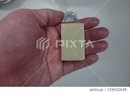 Hand Holding Soap Over Sink 139432696