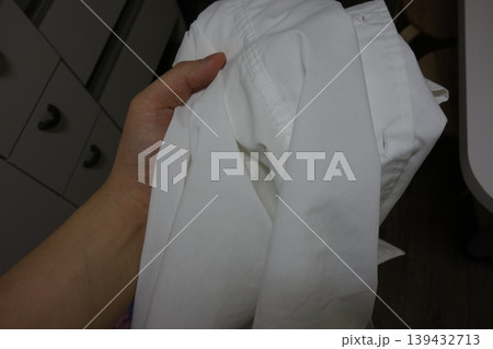 Hand Holding White Pants Close-Up 139432713