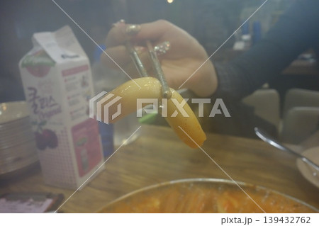 Tongs Holding Steamed Food Over Hot Pot 139432762