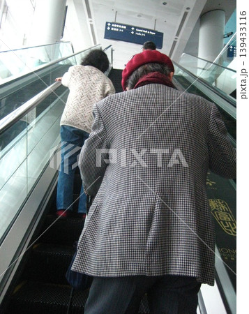 Elderly Couple on Escalator in Modern Building Elderly Couple on Escalator in Modern Building 139433116