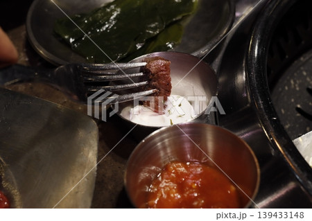 Forked Steak with Cream and Sauce on Metal Plate 139433148