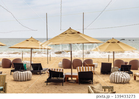 Inviting beachfront lounge area with comfortable seating and open umbrellas, perfect for a relaxing and luxurious seaside escape. Sri Lanka island in Asia. 139433273
