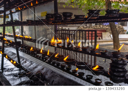 Abundant Clay Oil Lamps with Warm Flames Illuminate a Spiritual Setting, Creating a Sense of Peace and Traditional Serenity. Sri Lanka island in Asia. Abundant Clay Oil Lamps with Warm Flames Illuminate a Spiritual Setting, Creating a Sense of Peace and Traditional Serenity. Sri Lanka island in Asia. 139433293