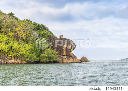 Lush Tropical Island Landscape with Rocky Coastline and Serene Blue Water Under a Cloudy Sky, Reflecting Nature's Tranquility. Sri Lanka island in Asia. 139433314