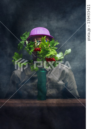 A man in a hat behind red viburnum branches 139433421