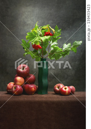 Still life with a branch of red viburnum in a vase and ripe apples Still life with a branch of red viburnum in a vase and ripe apples 139433423