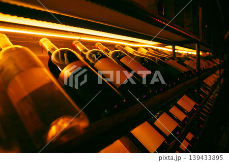 Dramatic wine shelf under warm light Dramatic wine shelf under warm light 139433895