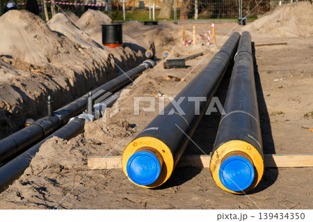 Insulated underground utility pipes prepared for trench installation at construction work site Insulated underground utility pipes prepared for trench installation at construction work site 139434350