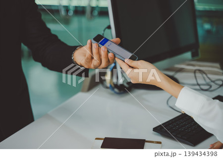 Closeup of airline staff scanning smartphone screen with boarding pass from business traveler Closeup of airline staff scanning smartphone screen with boarding pass from business traveler 139434398