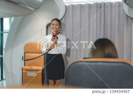 Cabin attendant giving welcome announcement during business class boarding Cabin attendant giving welcome announcement during business class boarding 139434407