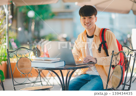Happy smiling student with book in hand on campus while going to study for learning. Happy smiling student with book in hand on campus while going to study for learning. 139434435