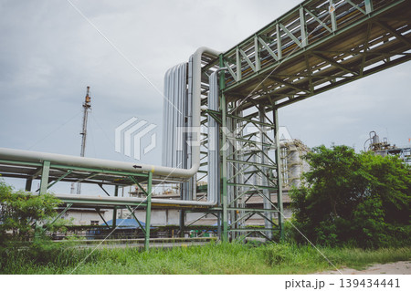 Oil and gas pipeline structure at refinery station with surrounding green area 139434441