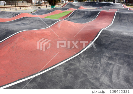 Outdoor red and black pump track at a skatepark for biking, skating and urban sports 139435321