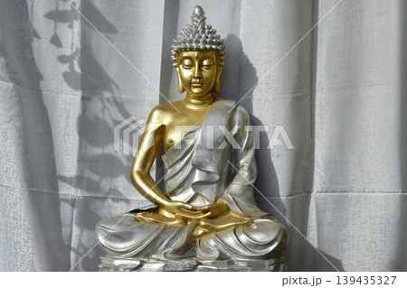 Golden and silver Buddha statue in meditation pose Golden and silver Buddha statue in meditation pose 139435327