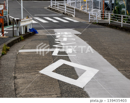 下り坂の路面標示　横断歩道ありのダイヤマークと速度落とせの文字 139435403