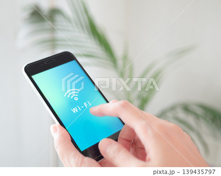 手に持ったスマホに表示されたWi-Fi (ワイファイ) のマーク。画面はオリジナル制作のイメージ画像 手に持ったスマホに表示されたWi-Fi (ワイファイ) のマーク。画面はオリジナル制作のイメージ画像 139435797