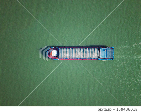 Barge travels on the river at daytime in China, carrying cargo under cover Barge travels on the river at daytime in China, carrying cargo under cover 139436018