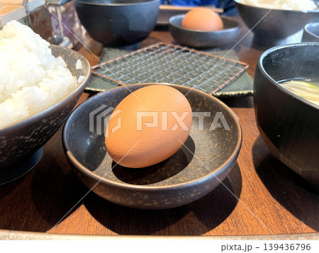 白米と生卵 ─ 黒い小皿に乗った生卵・和定食テーブルセット 白米と生卵 ─ 黒い小皿に乗った生卵・和定食テーブルセット 139436796