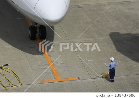 旅客機を誘導するグランドハンドラー 旅客機の到着 グラハンのハンドサイン 旅客機を誘導するグランドハンドラー 旅客機の到着 グラハンのハンドサイン 139437606