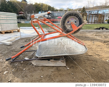 a close-up view of construction equipment resting on a mound of earth at an outdoor work site. 139438072