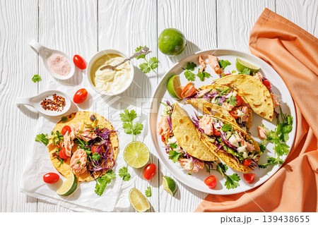 salmon tacos drizzled with sauce on a plate 139438655
