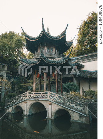 Hangzhou Deshou Palace garden scene with a historic Chinese pavilion and stone arched bridge over reflective water Hangzhou Deshou Palace garden scene with a historic Chinese pavilion and stone arched bridge over reflective water 139439076