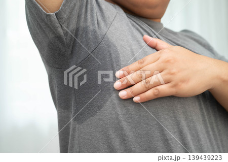 Sweaty underarms, Asian woman with sweat on clothes under armpit. Sweaty underarms, Asian woman with sweat on clothes under armpit. 139439223