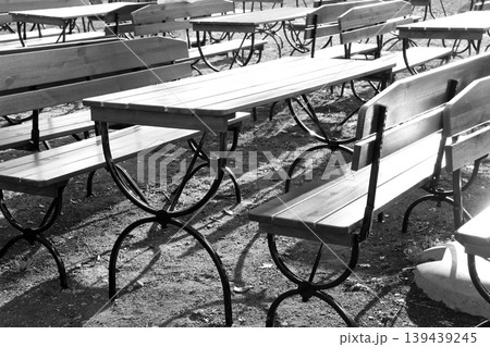 Empty Outdoor Cafe Seating with Vintage Metal and Wood Tables in Black and White Empty Outdoor Cafe Seating with Vintage Metal and Wood Tables in Black and White 139439245