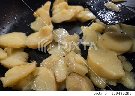 Sauteed Potatoes Cooking in Black Skillet - Perfect for Rustic Culinary Designs 139439299
