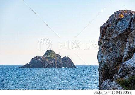 青い海に浮かぶ孤島と力強い岩肌の海岸風景 139439358