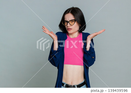 Woman shrugging shoulders scratching head confused uncertain expression not knowing puzzled mood Woman shrugging shoulders scratching head confused uncertain expression not knowing puzzled mood 139439596