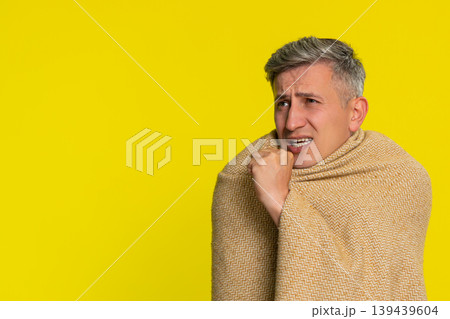 Adult man wrapped in blanket coughing with tired sick face showing flu symptoms cold virus illness Adult man wrapped in blanket coughing with tired sick face showing flu symptoms cold virus illness 139439604